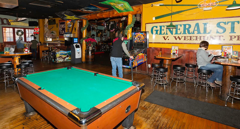 The interior of the Rock Rest features predictable furnishings like a pool table and arcade games, but also less-typical fare, such as a rhino head with a beer spout and a bra-strewn motorcycle.
